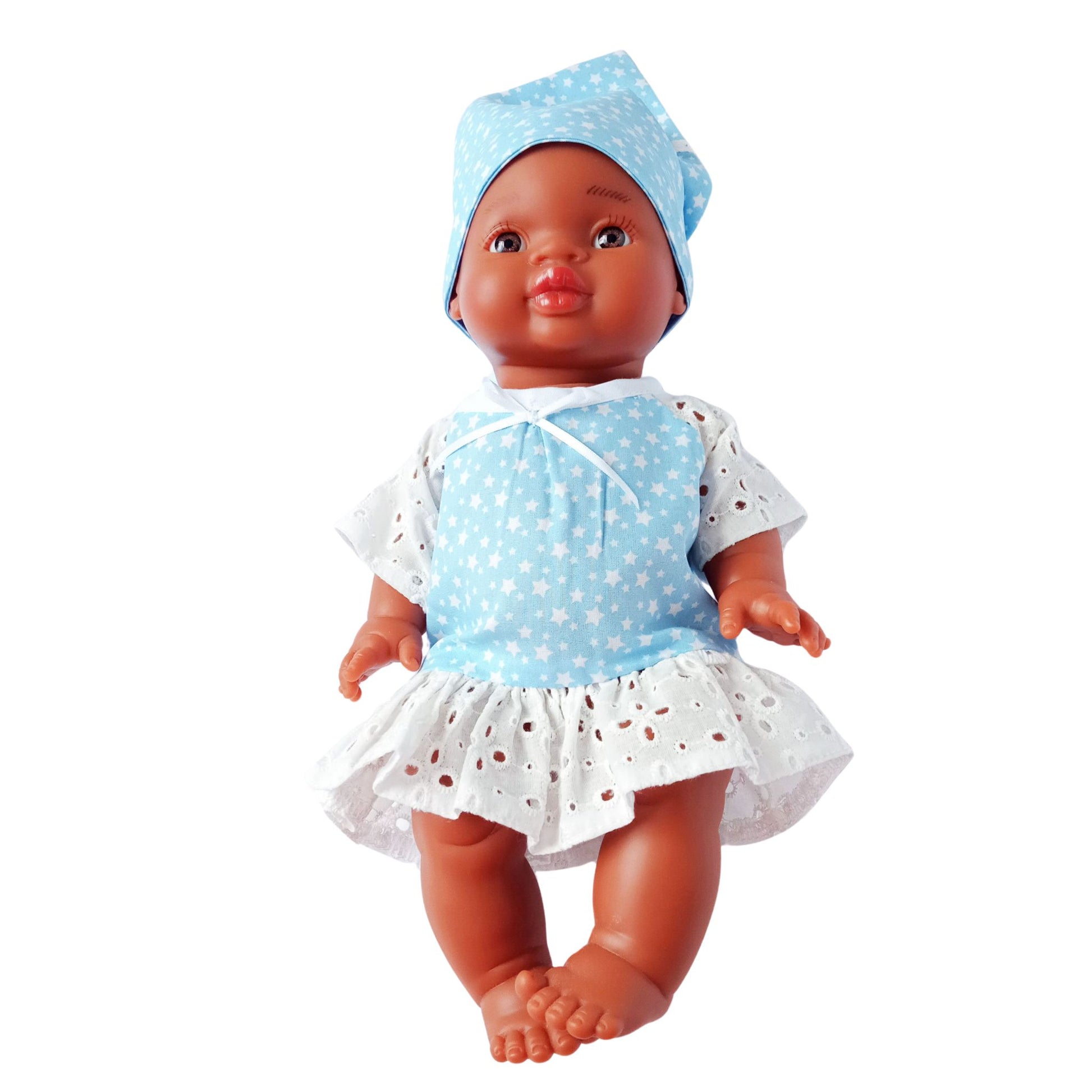 Dark-skinned baby doll wearing a blue star-print cotton dress with white eyelet lace and a matching kerchief, made for 34 cm dolls like Paola Reina and Baby Born.