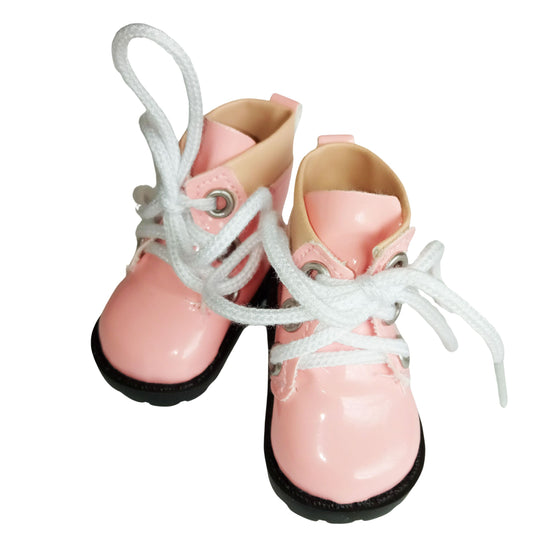 A pair of light pink lace-up boots with chunky black soles, designed for 32 cm Paola Reina dolls. The boots feature white laces and soft beige accents around the ankle.