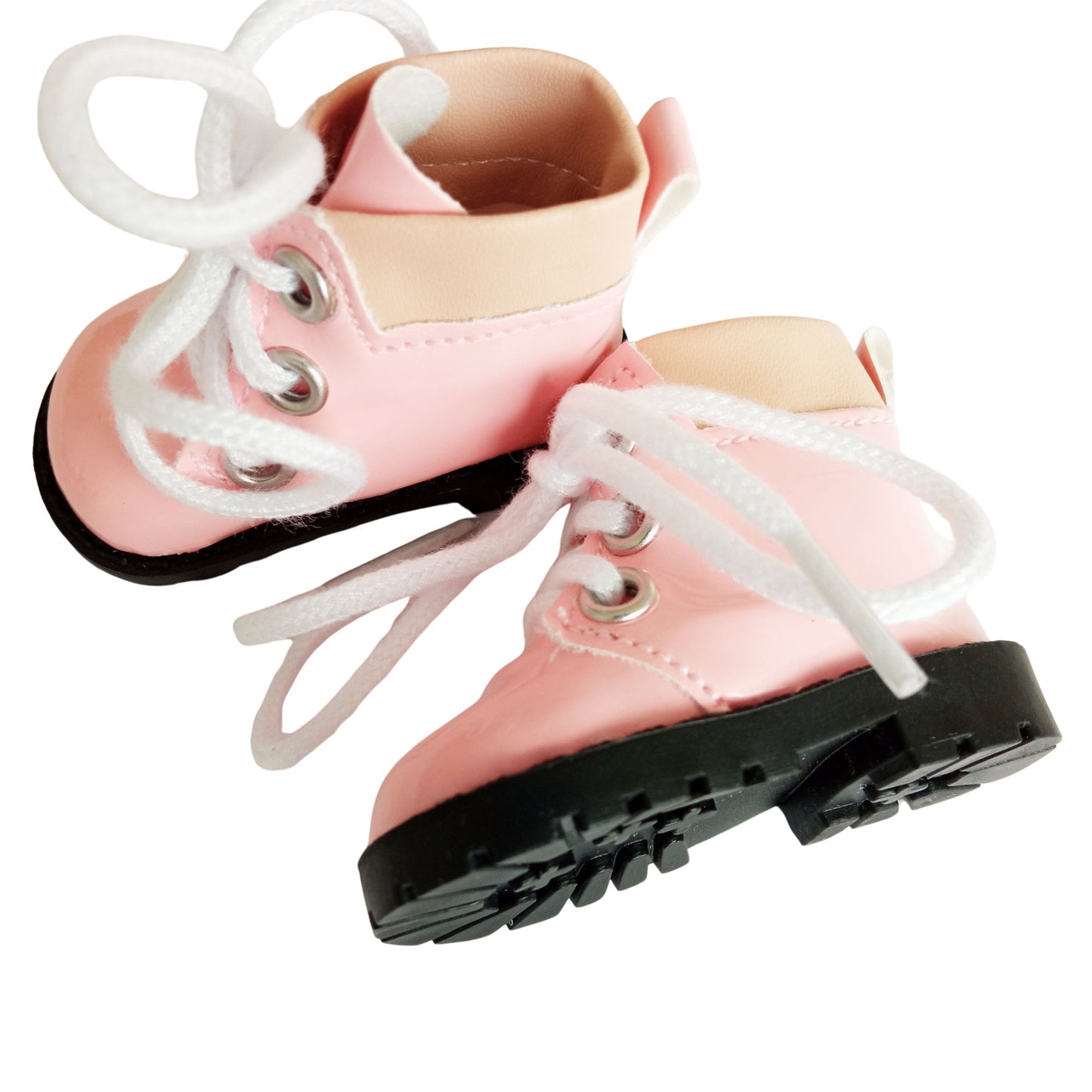 A pair of light pink lace-up boots with chunky black soles, designed for 32 cm Paola Reina dolls. The boots feature white laces and soft beige accents around the ankle.