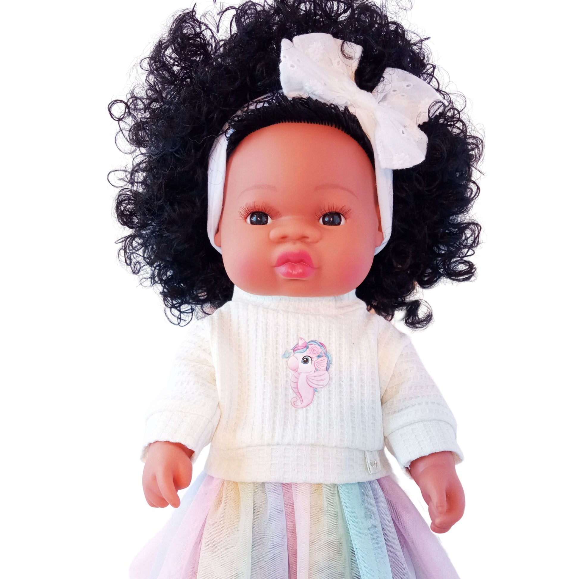 Doll wearing a pastel rainbow skirt and cream knit blouse with unicorn-seahorse print, styled for Paola Reina or Baby Born 34 cm dolls.