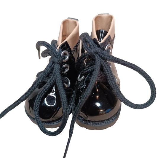 Glossy black lace-up boots with beige cuffs, designed for 32 cm Paola Reina dolls. Featuring black laces, metal eyelets, and a chunky sole for a bold fashion statement.