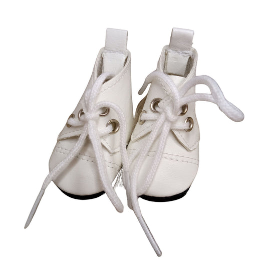 A pair of white lace-up boots for dolls, featuring silver eyelets and black soles, perfect for adding stylish charm to any doll outfit.