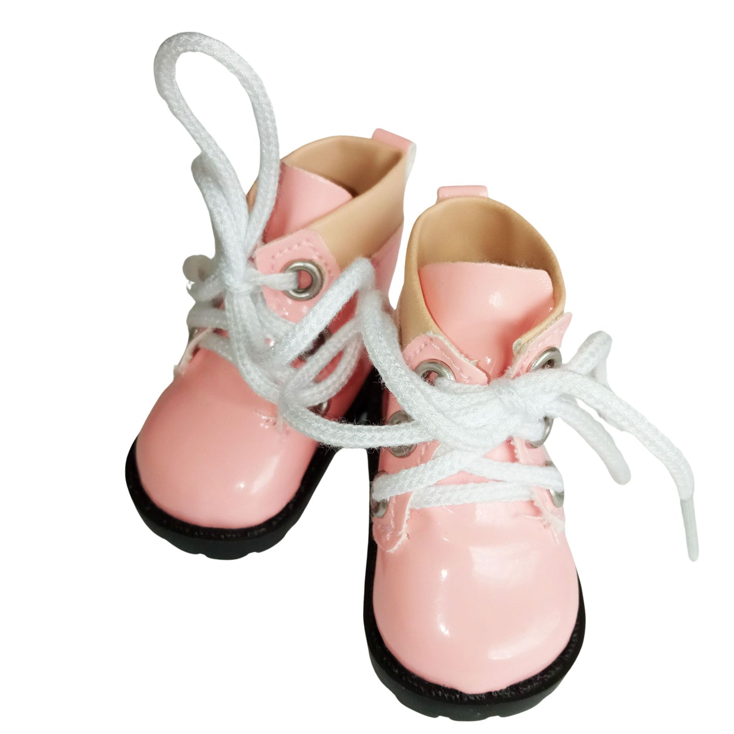 A pair of light pink lace-up boots with chunky black soles, designed for 32 cm Paola Reina dolls. The boots feature white laces and soft beige accents around the ankle.

